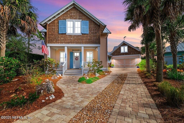 view of front of home with a garage, an outdoor structure, and covered porch