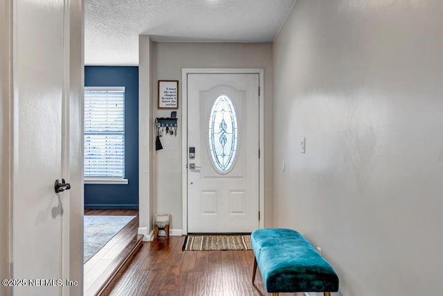 foyer entrance featuring dark wood-type flooring and a textured ceiling