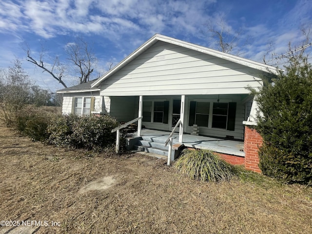 rear view of property with covered porch