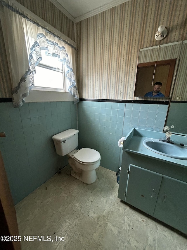 bathroom featuring vanity, toilet, and tile walls