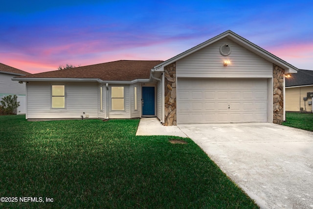 ranch-style home featuring a garage, stone siding, driveway, and a front lawn