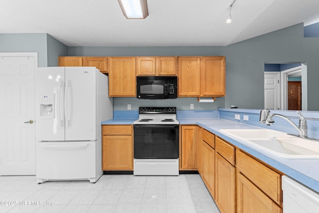 kitchen featuring light tile patterned floors, a textured ceiling, white appliances, a sink, and light countertops