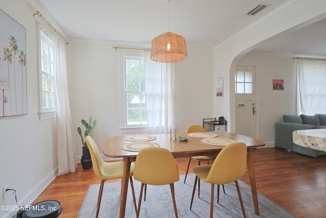 dining room with hardwood / wood-style flooring, ornamental molding, and a wealth of natural light