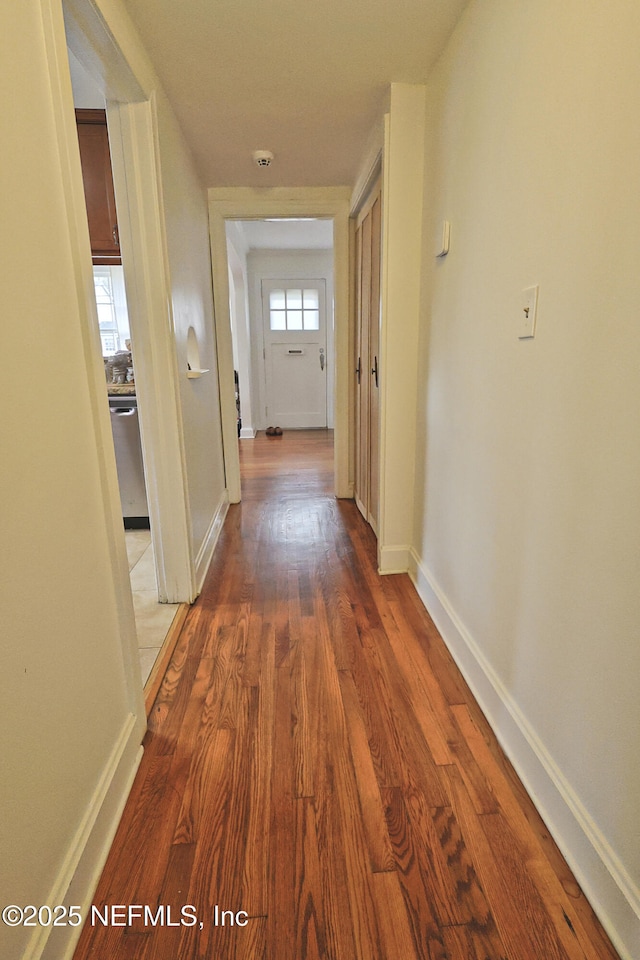 corridor with hardwood / wood-style flooring