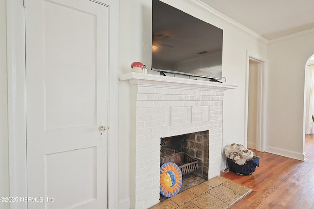 interior details with crown molding, hardwood / wood-style floors, and a fireplace