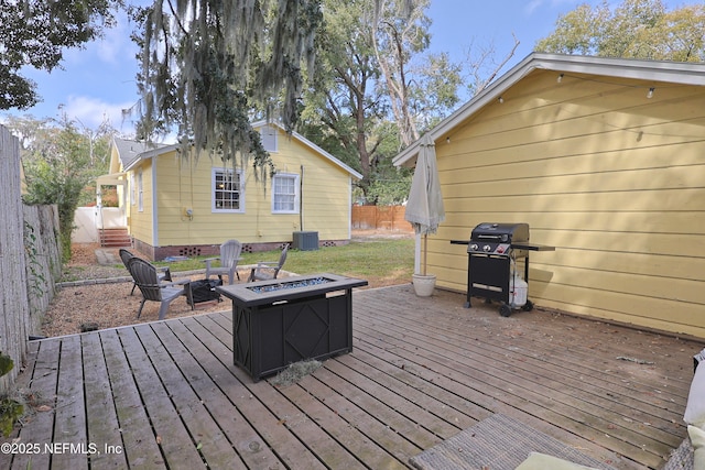 wooden deck with area for grilling, central AC unit, and a fire pit