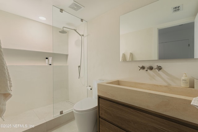 bathroom with vanity, toilet, and a tile shower