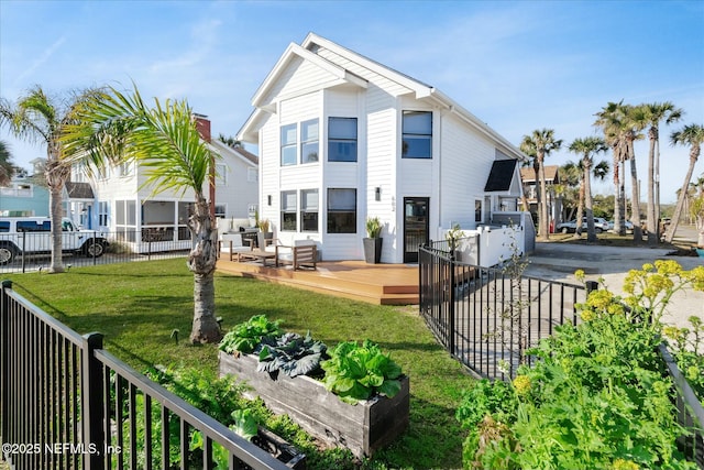 rear view of property featuring a deck and a lawn