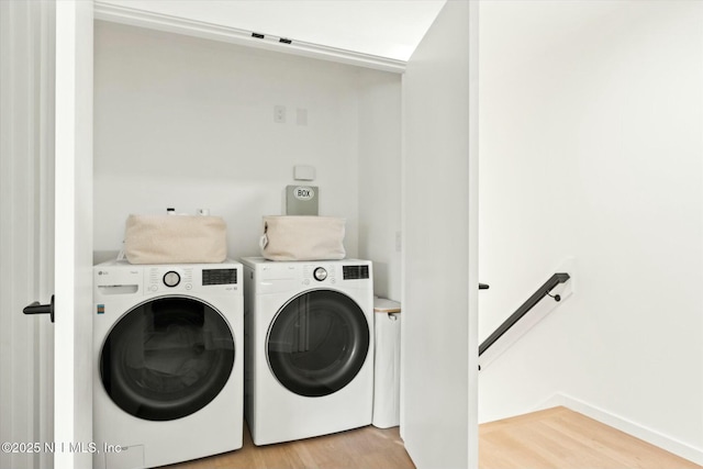 laundry area with light wood-type flooring and washer and clothes dryer