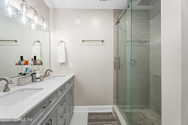 bathroom featuring a shower with door and vanity