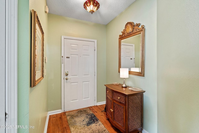 foyer featuring light hardwood / wood-style flooring and a textured ceiling