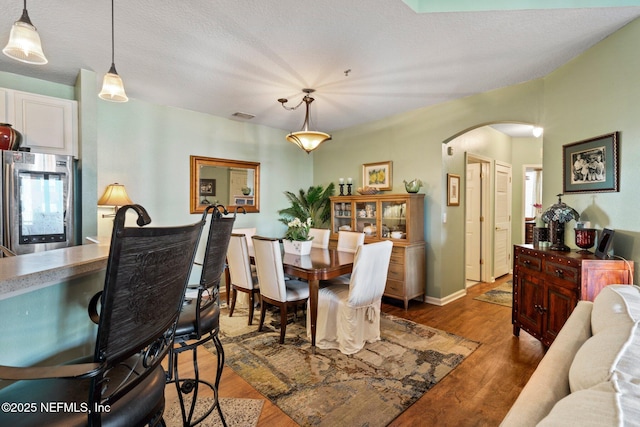 dining room featuring hardwood / wood-style floors and a textured ceiling