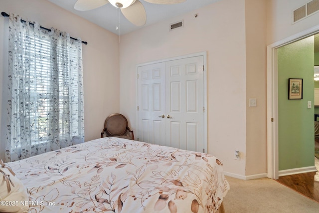 carpeted bedroom featuring ceiling fan and a closet