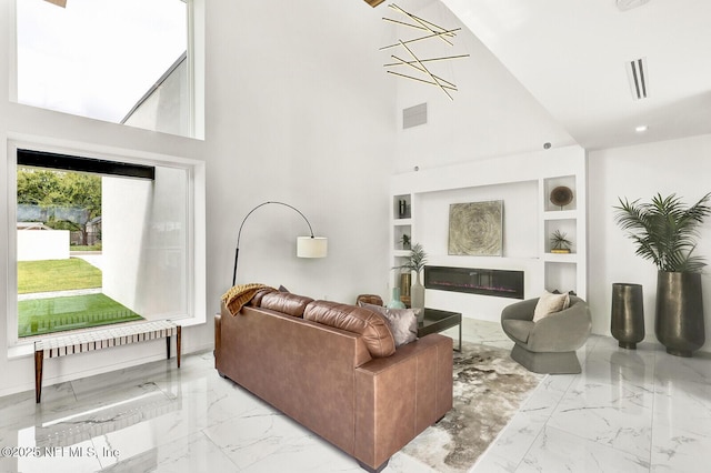 living room with a towering ceiling and built in features