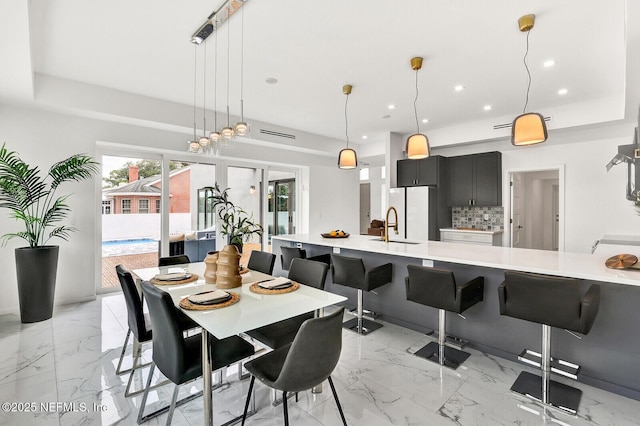 dining space with a raised ceiling and sink