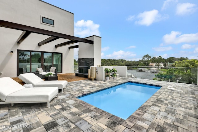 view of pool with a water view and a patio area