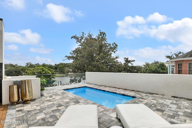 view of swimming pool featuring a hot tub, a water view, and a patio area