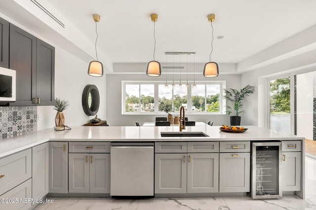 kitchen featuring gray cabinetry, pendant lighting, beverage cooler, and dishwasher