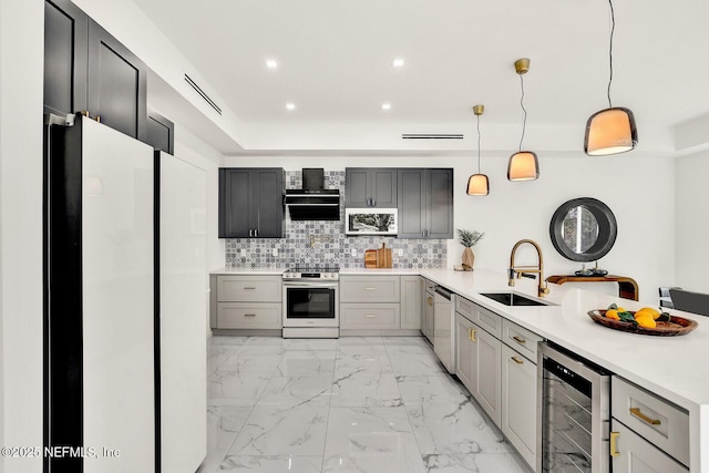 kitchen with hanging light fixtures, appliances with stainless steel finishes, gray cabinets, and beverage cooler