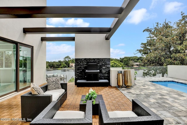 view of patio / terrace with a water view and an outdoor living space with a fireplace