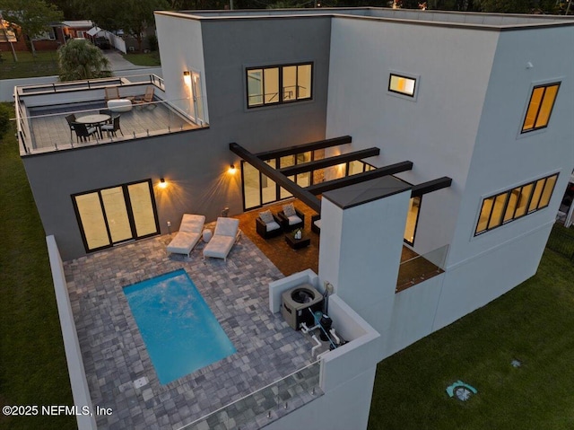 back of house featuring a patio and an outdoor living space with a fire pit