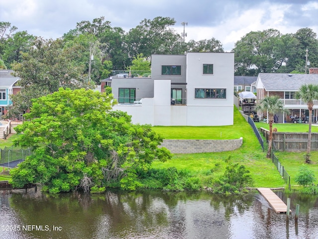 rear view of house with a water view and a yard