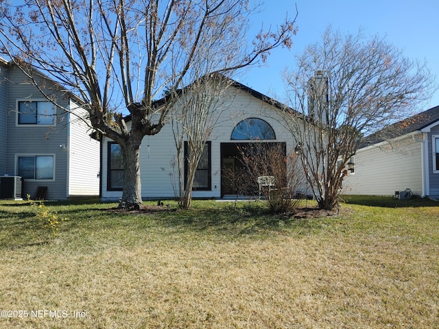 view of front facade with a chimney, central AC, and a front yard