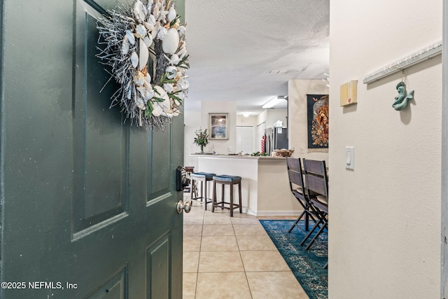 tiled foyer featuring a textured ceiling