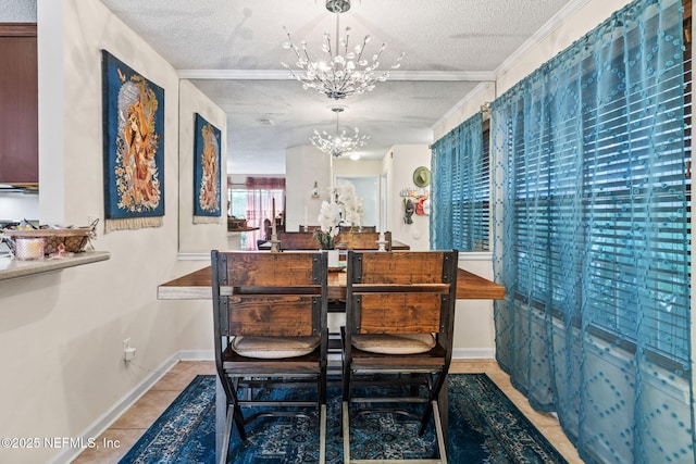 tiled dining room featuring a textured ceiling, ornamental molding, and a chandelier