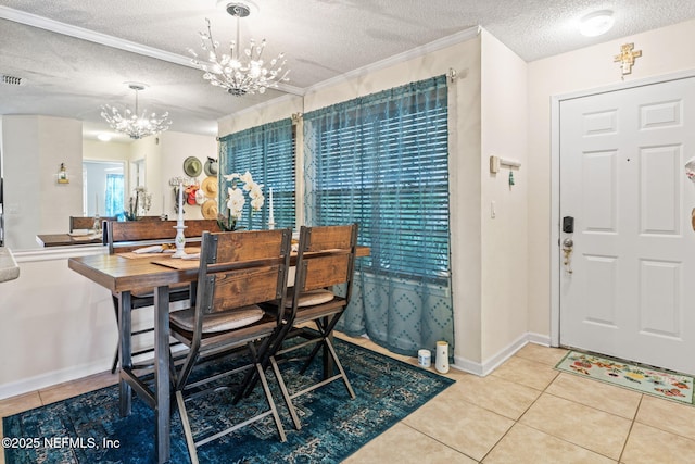 dining space with tile patterned flooring, ornamental molding, a textured ceiling, and an inviting chandelier