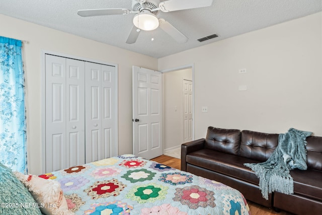 bedroom featuring hardwood / wood-style flooring, ceiling fan, a textured ceiling, and a closet