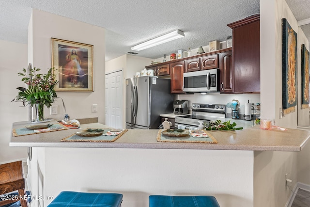 kitchen with a breakfast bar area, stainless steel appliances, and kitchen peninsula