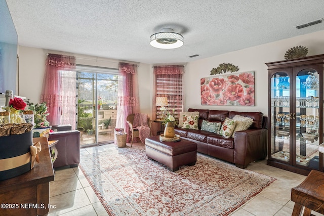 living room featuring light tile patterned flooring, a textured ceiling, and french doors