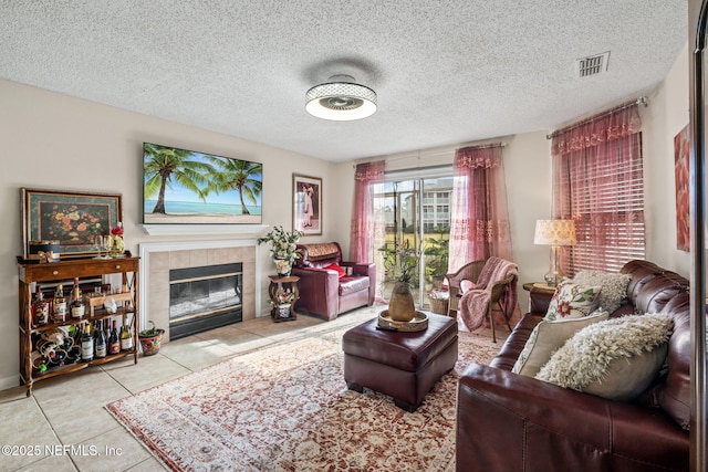 tiled living room with a tiled fireplace and a textured ceiling