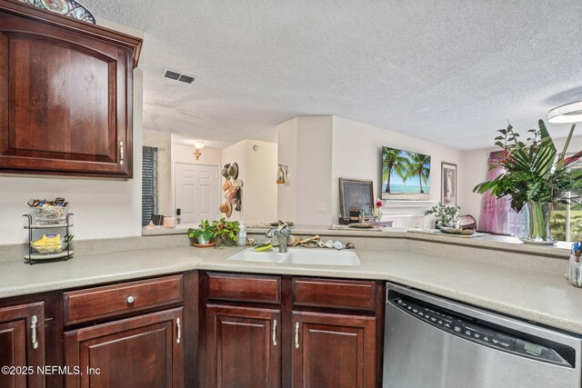 kitchen with sink, stainless steel dishwasher, kitchen peninsula, and a textured ceiling