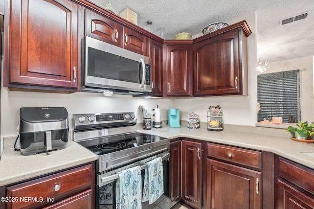 kitchen featuring stainless steel appliances and a textured ceiling