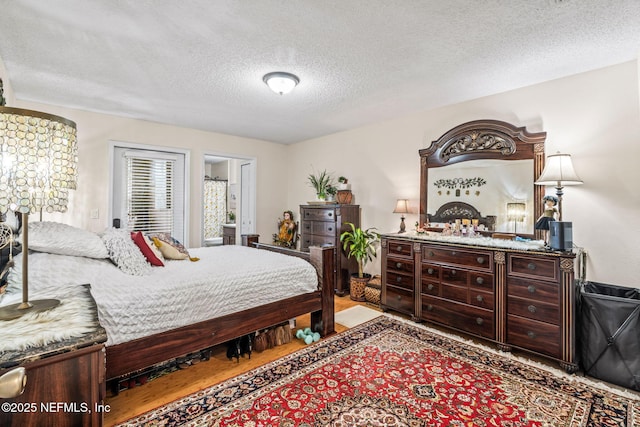 bedroom featuring wood-type flooring and a textured ceiling