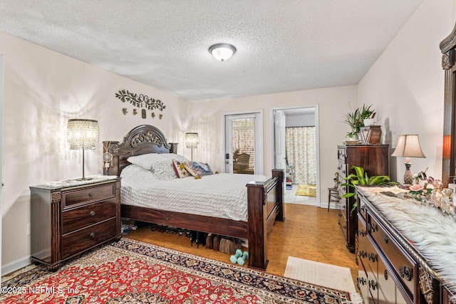 bedroom featuring a textured ceiling and light hardwood / wood-style flooring