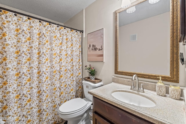 bathroom with vanity, toilet, and a textured ceiling