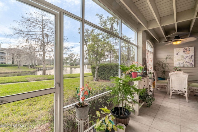 sunroom / solarium featuring beamed ceiling, a water view, and ceiling fan