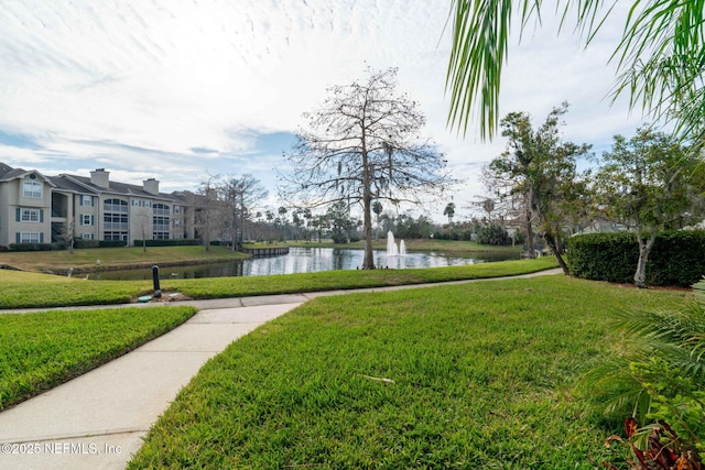 view of property's community featuring a water view and a yard