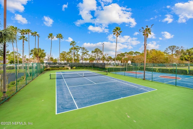 view of tennis court featuring fence