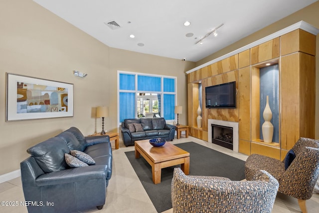 living area featuring a fireplace with flush hearth, visible vents, baseboards, and light tile patterned flooring