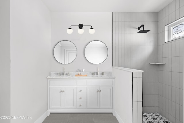 bathroom featuring double vanity, baseboards, a walk in shower, and a sink