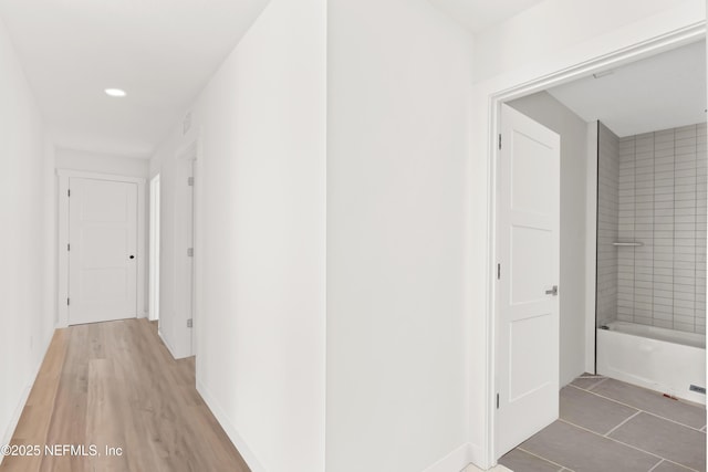 hallway featuring recessed lighting, light wood finished floors, and baseboards