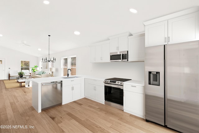 kitchen with a sink, white cabinetry, light countertops, appliances with stainless steel finishes, and light wood-type flooring