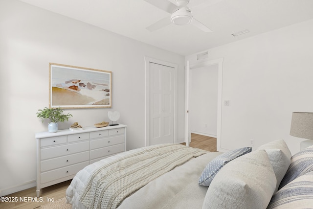 bedroom featuring baseboards, light wood-style flooring, and a ceiling fan