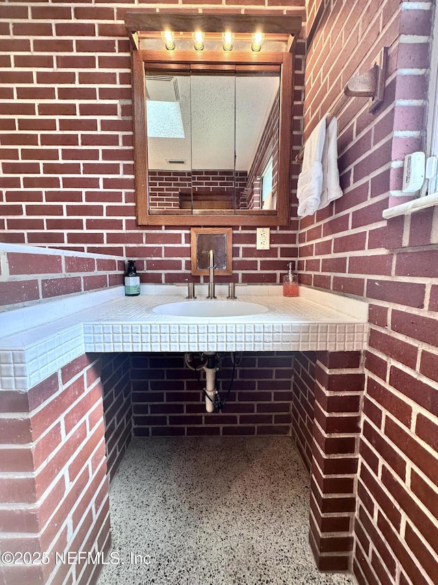 bathroom with brick wall and sink