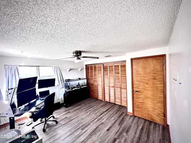 unfurnished office with hardwood / wood-style flooring, ceiling fan, and a textured ceiling