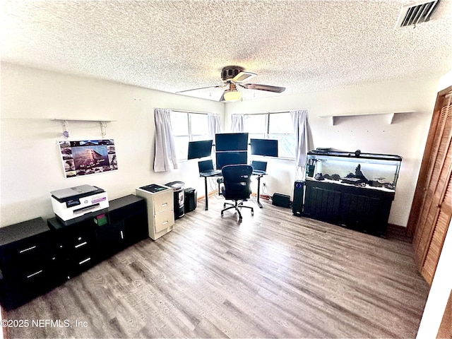 office space featuring ceiling fan, a textured ceiling, and light wood-type flooring